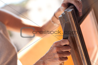 Woman polishing a window with a putty knife