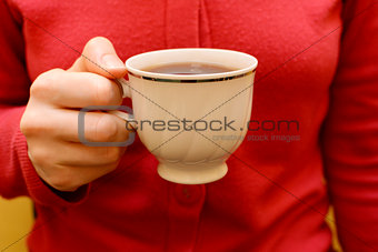 Woman with a cup of black tea in her hand