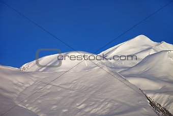 Off-piste slope and blue clear sky in nice winter morning