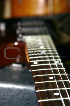 close up of guitar neck on blurred background