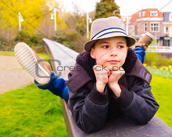 Cute teenage boy lying on the parapet at the park