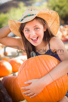 Preteen Girl Holding A Large Pumpkin at the Pumpkin Patch 
