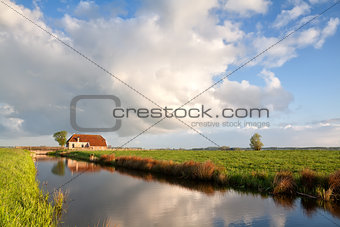 cozy farmhouse by river in morning light