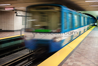 Moving subway train with an empty subway platform. 
