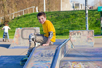 smiling teenage boy in roller-blading protection kit in a skate 