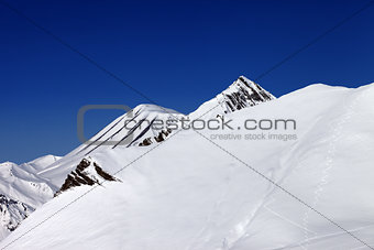 Off-piste slope with traces of skis in nice day