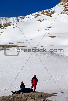 Two hikers on halt in snow mountains