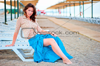 Beautiful young girl posing on a beach lounger