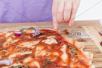 hand making fresh pizza on wooden board