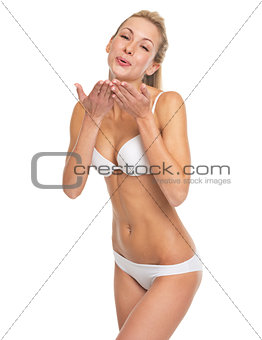 Happy young woman in lingerie blowing air kiss