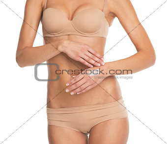 Closeup on young woman in lingerie applying creme on hand