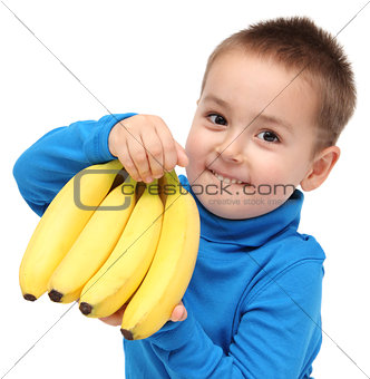 little boy holds bananas