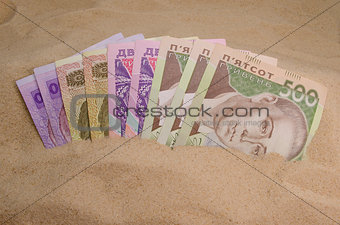 ukrainian money in sand