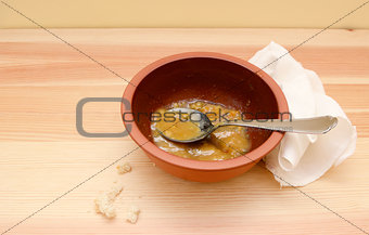 Empty soup bowl with crumbs and a used linen napkin