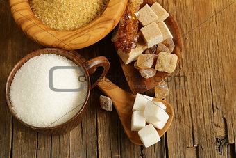 different kinds of sugar - brown, white, refined sugar on a wooden background