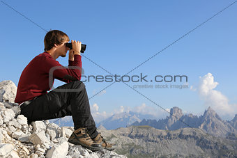 Searching the destination through binoculars in the mountains