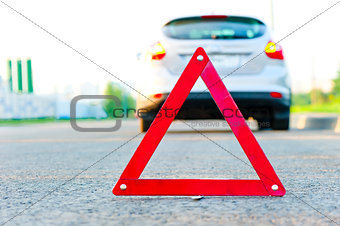 red warning triangle and a car with the emergency alarm
