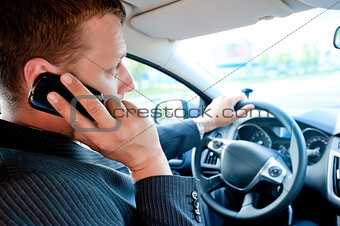 male businessman talking on a cell phone while driving