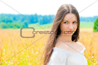 beautiful young Russian girl in a field with gold ears of wheat