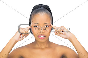 Attractive woman pointing to her head and looking at camera