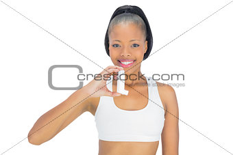 Smiling woman holding asthma inhaler while looking at camera