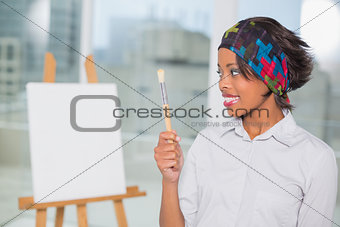 Pretty artist looking at her brush