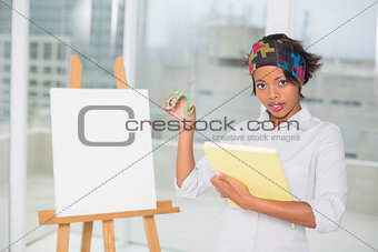 Attractive artistic woman holding sketchpad and scissors