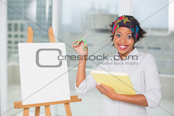 Funny artistic woman holding scissors and sketchpad