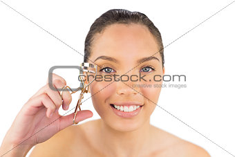 Smiling woman with eyelash curler