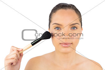 Attractive woman using a powder brush