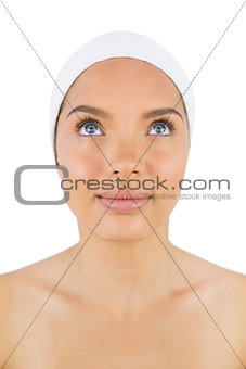 Smiling woman wearing white headband looking upwards