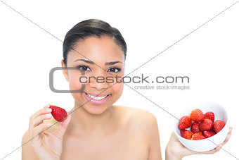 Content young dark haired model eating strawberries