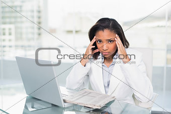 Puzzled young dark haired businesswoman trying to understand a document