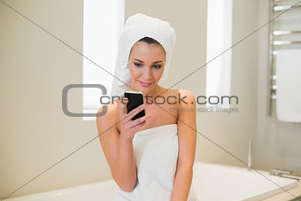 Pleased natural brown haired woman using her mobile phone