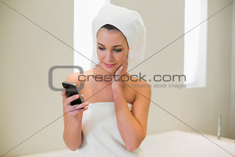 Pensive natural brown haired woman using her mobile phone