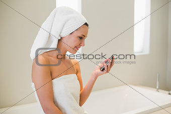 Joyful natural brown haired woman using a mobile phone