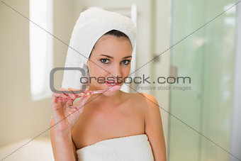 Charming natural brown haired woman using a toothbrush