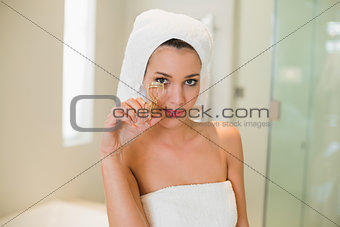 Calm natural brown haired woman using eyelash curler