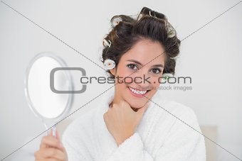 Gleeful natural brunette holding hand mirror