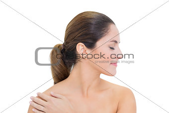 Smiling bare brunette turning head right with closed eyes