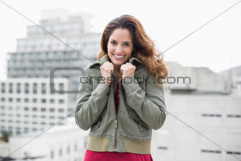 Smiling gorgeous brunette in winter fashion grabbing collar