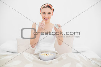 Smiling young woman watching television