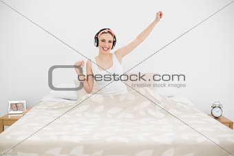 Pretty woman listening to music and smiling into the camera
