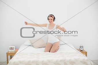 Pretty woman moving on her bed while listening to music