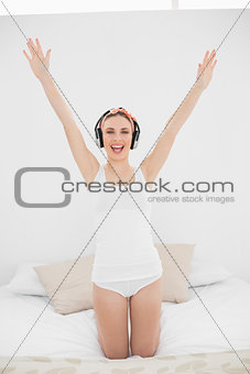 Woman raising her arms while listening to music