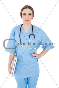 Young female doctor holding a notebook and looking into the camera