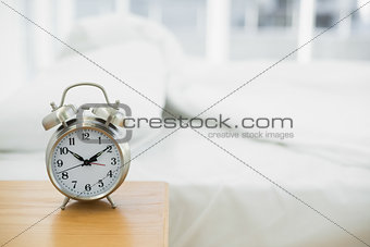 Retro alarm clock standing on a bedside table