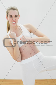 Focused fit woman in sportswear practising martial arts