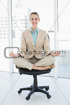 Beautiful classy woman sitting in lotus position on her swivel chair