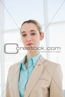 Lovely chic businesswoman posing seriously in her office